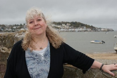 Helen Hollick at Instow in
                North Devon with Appledore in the background (photo
                courtesy of ‘ Bideford People’)